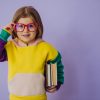 Cute little girl holding books isolated in studio